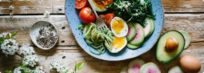 A delicious looking salad with avocado, cucumbers, tomato and mixed greens